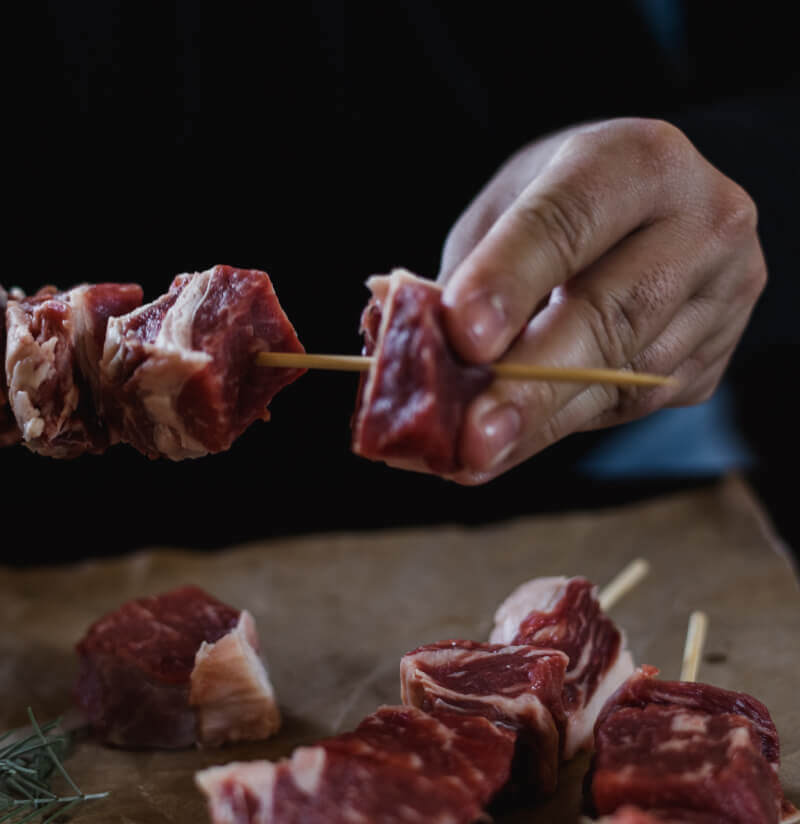 chef placing premium beef on a skewer